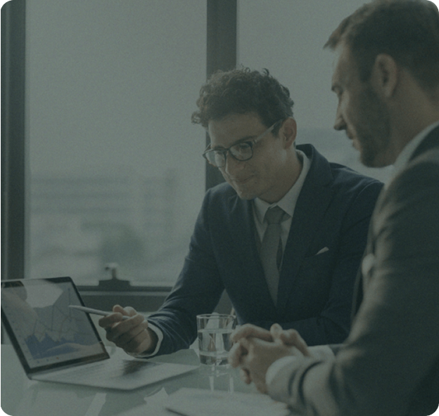 Investment advisors reviewing a client portfolio on a laptop